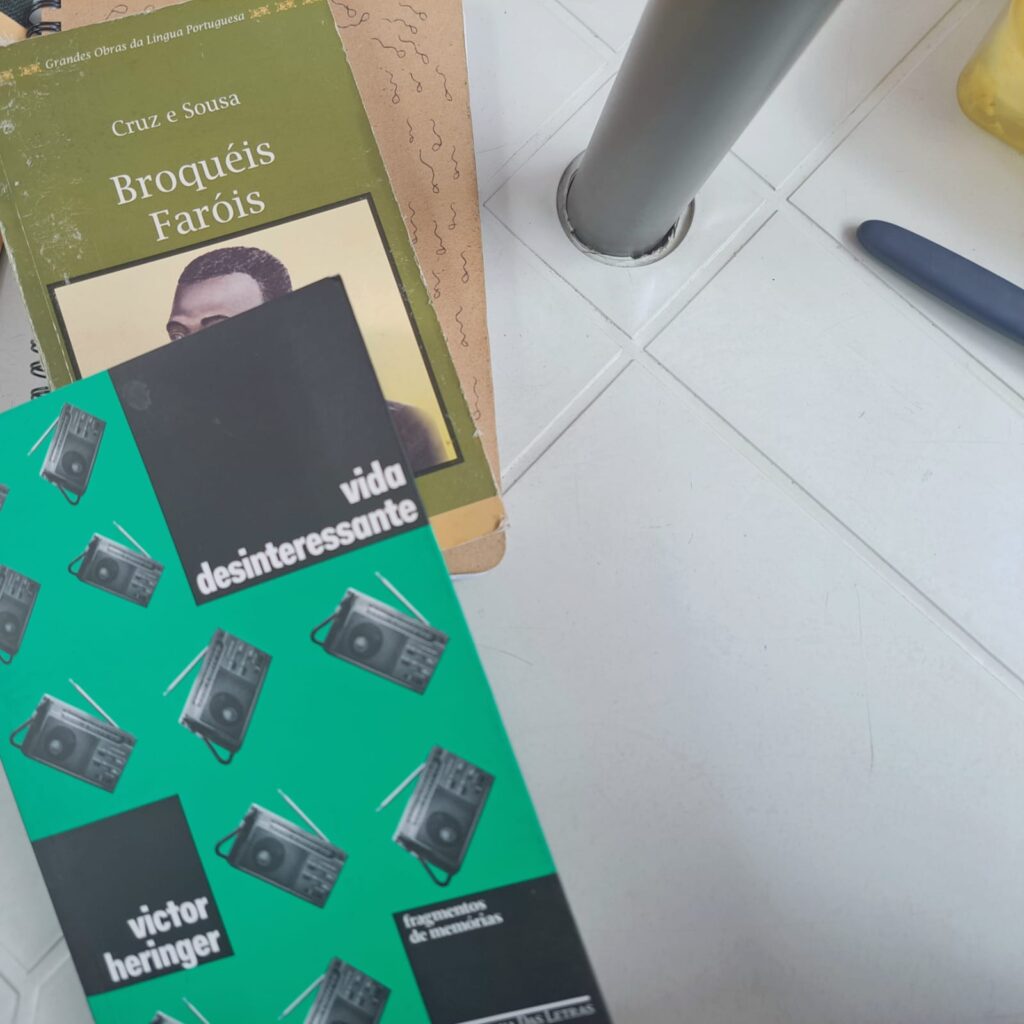 Livros de Victor Heringer e Cruz e Souza sobre mesa de plástico branca